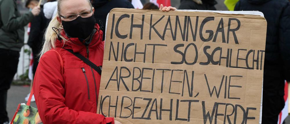 Eine Mitarbeiterin des öffentlichen Dienst demonstriert für bessere Arbeitsbedingungen. 