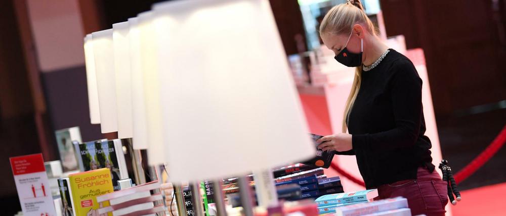 Viele Bücherstapel, wenig Besucher. Eine Mitarbeiterin der Frankfurter Buchmesse an einem Verlagsstand in der Festhalle. 