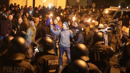 Thüringen, Greiz: Polizisten und Teilnehmer eines so genannten Spaziergangs gegen die Corona-Maßnahmen stehen sich am Abend gegenüber.  