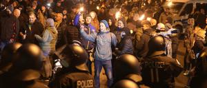 Thüringen, Greiz: Polizisten und Teilnehmer eines so genannten Spaziergangs gegen die Corona-Maßnahmen stehen sich am Abend gegenüber.  