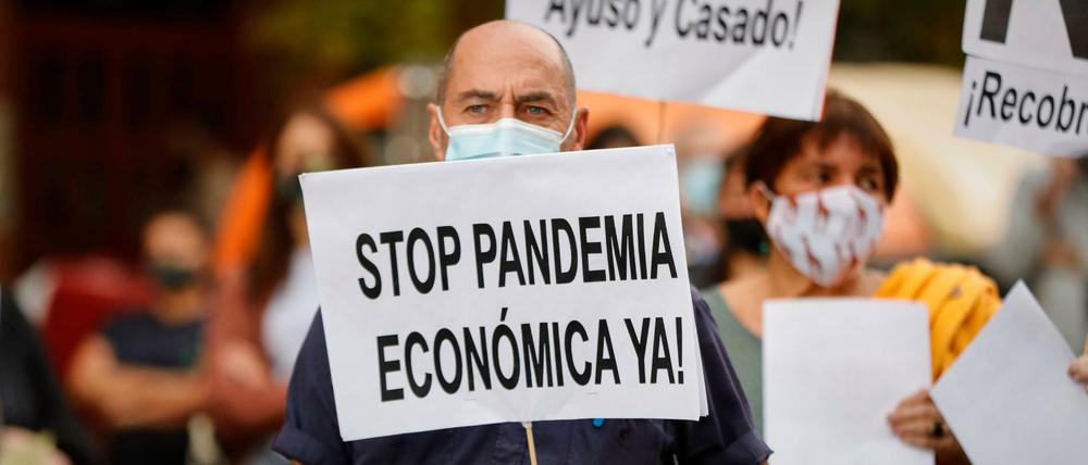 Krise in Spanien: «Stoppt die Wirtschaftspandemie sofort!», steht auf dem Plakat eines Demonstranten in Madrid.
