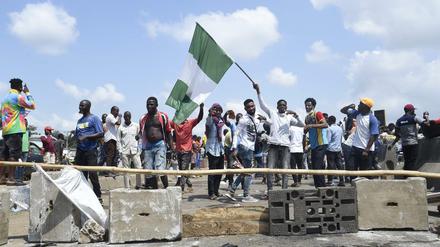 Ein Demonstrant schwenkt bei Protesten die nigerianische Flagge.