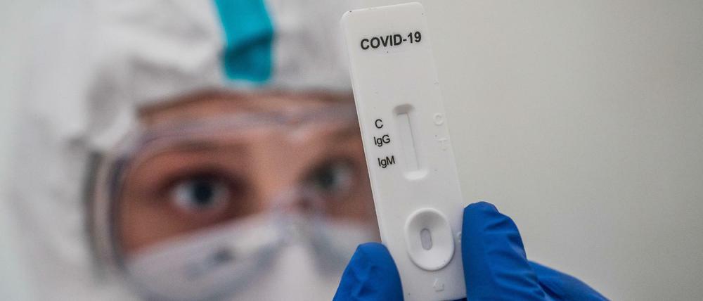 Medizinisches Personal prüft einen Schnelltest zum Corona-Antikörper-Nachweis.