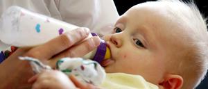 Eine Mutter gibt ihrem Säugling die Flasche.