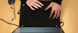 Im Bild ist ein Laptop, auf der eine Person mit beiden Händen tippt.