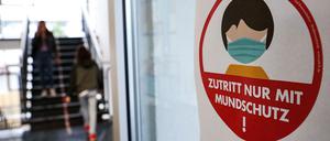 In einer hessischen Schule weist ein Schild auf die Maskenpflicht hin. 