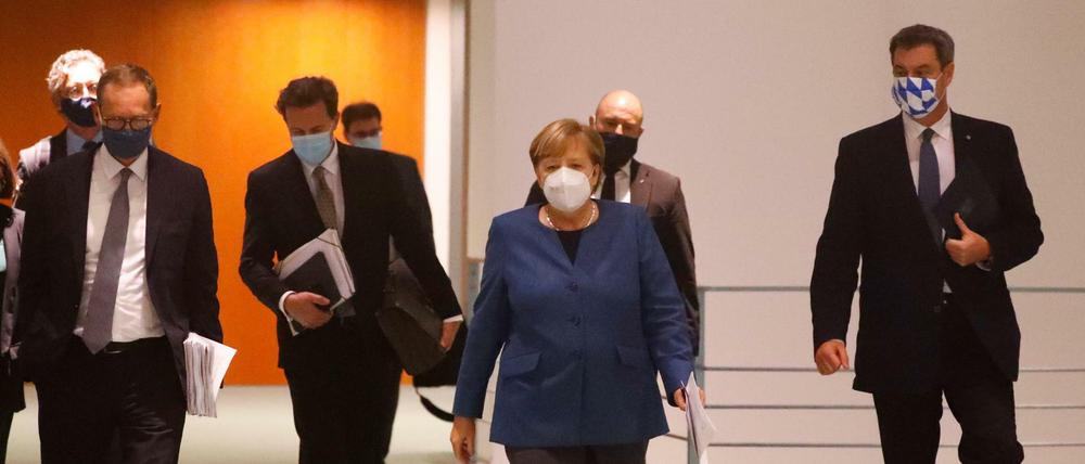 Bundeskanzlerin Angela Merkel (CDU), der bayerische Ministerpräsident Markus Söder (CSU) und Berlins Regierender Bürgermeister Michael Müller (SPD) kommen zu der Pressekonferenz am 28. Oktober 2020.