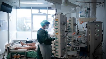 Eine Mitarbeiterin der Pflege in Schutzausrüstung betreut einen Corona-Patienten. Menschen mit Corona-Infektion werden auf der Intensivstation IT2 im Operativen Zentrum II des Universitätsklinikum Essen behandelt. 