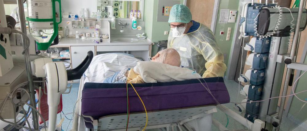 Arzt und Patient in einem isoliertem Intensivbett-Zimmer.