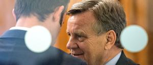 Ex-BER-Chef Hartmut Mehdorn unterhält sich hinter einer Glastür auf der Sitzung der Fluglärmkommission in Schönefeld (Brandenburg).