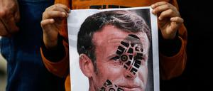 Ein Kind hält ein mit einem Schuhabdruck versehenes Foto des französischen Staatschefs Emmanuel Macron in Istanbul in die Kamera.