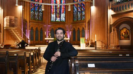 Der israelische Klarinettist Nur Ben Shalom vor Kirchenbänken in der Apostel-Paulus-Kirche in Berlin-Schöneberg.