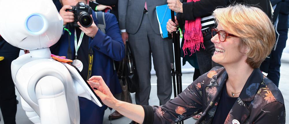 Forschungsministerin Anja Karliczek (CDU) kommuniziert mit einem humanoiden Roboter.
