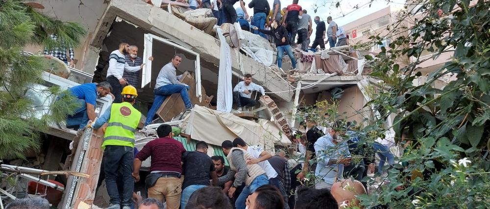 Bewohner und Helfer suchen nach Überlebenden in eingestürzten Gebäuden im türkischen Izmir.