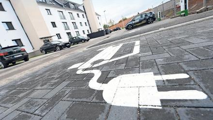 Eine Piktogramm auf dem Asphalt weist im neuen Hanauer Wohngebiet „Pioneer Park“, das auf dem Gelände einer ehemaligen US-Kaserne entsteht, auf den Stellplatz für eine E-Auto-Ladesäule hin. Das neue Wohngebiet will zeigen, wie sich E-Mobilität in den Alltag integrieren lässt. Die Stadt und ihr Projektpartner sprechen von einem bundesweiten Modellcharakter.