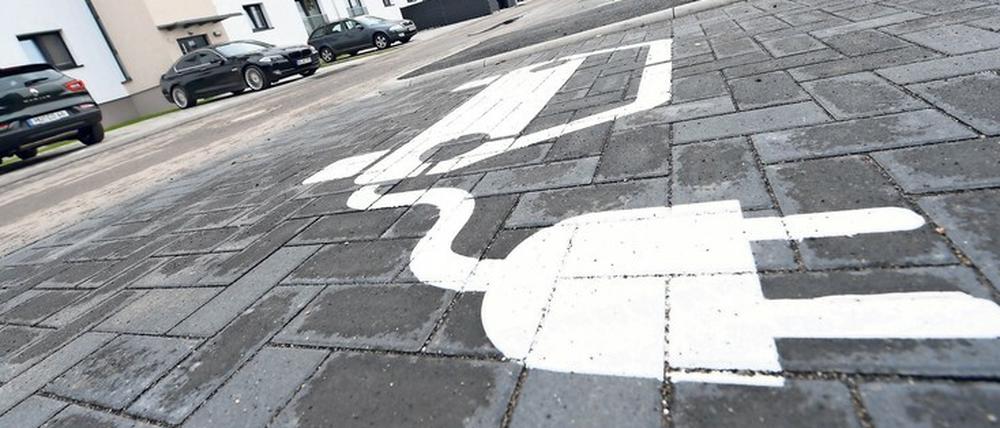 Eine Piktogramm auf dem Asphalt weist im neuen Hanauer Wohngebiet „Pioneer Park“, das auf dem Gelände einer ehemaligen US-Kaserne entsteht, auf den Stellplatz für eine E-Auto-Ladesäule hin. Das neue Wohngebiet will zeigen, wie sich E-Mobilität in den Alltag integrieren lässt. Die Stadt und ihr Projektpartner sprechen von einem bundesweiten Modellcharakter.