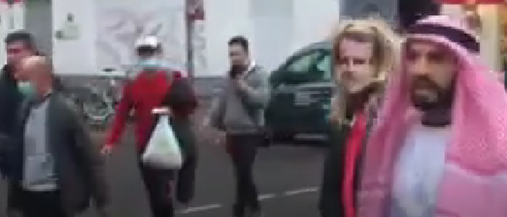 Rechts im Bild der Youtuber Fayez Kanfash, links neben ihm zerrt er die Person mit Macron-Maske hinter sich her. Das Video wurde von einem Passanten aufgenommen.