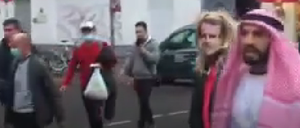 Rechts im Bild der Youtuber Fayez Kanfash, links neben ihm zerrt er die Person mit Macron-Maske hinter sich her. Das Video wurde von einem Passanten aufgenommen.
