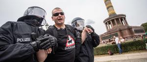 Ein Mann wird bei einem Protest gegen die Corona-Maßnahmen vor der Siegessäule von Polizisten abgeführt. 