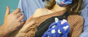 Ein Kinderarzt impft ein 7-jähriges Mädchen gegen das Covid19-Virus. 