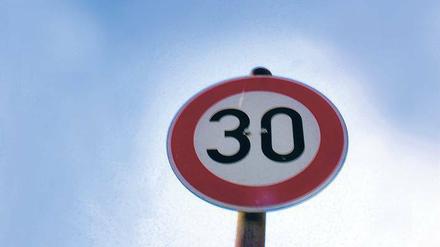 Tempo-30-Schild unter blauem Himmel.