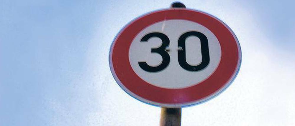 Tempo-30-Schild unter blauem Himmel.