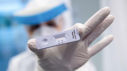 Eine Frau hält am Flughafen München in einem Covid-19 Testcenter einen Antigen-Schnelltest