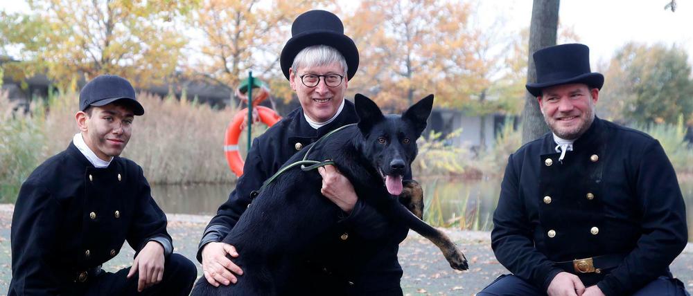 Die Schornsteinfeger Ilian Romero, Schornsteinfeger Norbert Skrobek, Schornsteinfeger Alain Raabsilber werben im Tierheim Berlin für die Vermittlung von schwarzen Tieren, wie Bonnie.