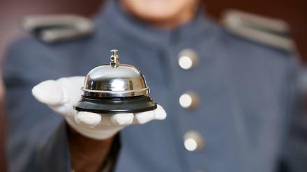 Hotelglocke auf der Hand von einem Concierge im Hotel (Symbolbild).