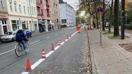 Am Montag pinselten Bauarbeiter die ersten weißen Streifen auf die Straße, Hütchen trennen den Radstreifen vom Autoverkehr.
