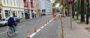 Am Montag pinselten Bauarbeiter die ersten weißen Streifen auf die Straße, Hütchen trennen den Radstreifen vom Autoverkehr.