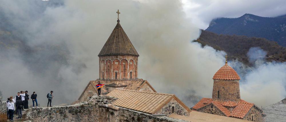 Armenier, einer von ihnen mit einer armenischen Nationalflagge, besuchen das orthodoxe Dadiwank-Kloster in Karvachar, Berg-Karabach.