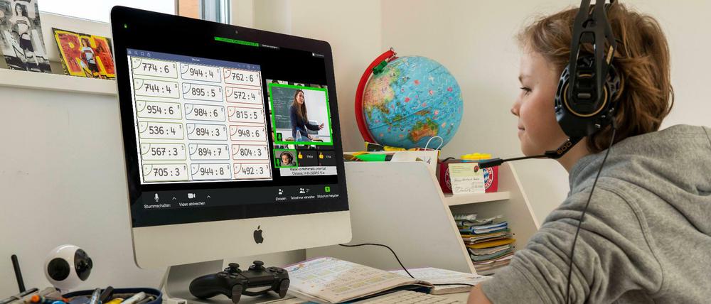 Ein Schüler sitzt vor einem Computer und löst Matheaufgaben.