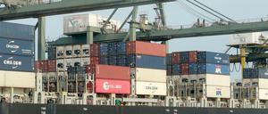 Container werden im Hafen auf ein Schiff verladen.