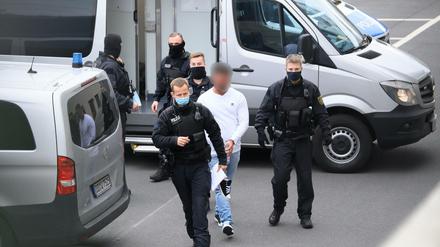 Ein verdächtiger Mann im Fall um den Kunstdiebstahl im Grünen Gewölbe wird von Polizisten in das Gebäude des Oberlandesgerichts geführt.