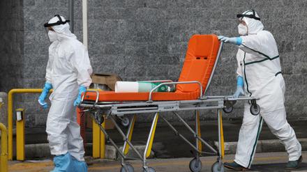 Krankenhausmitarbeiter holen mit einer Bahre einen covid-kranken Menschen in Neapel für den Transport ins Krankenhaus ab. 