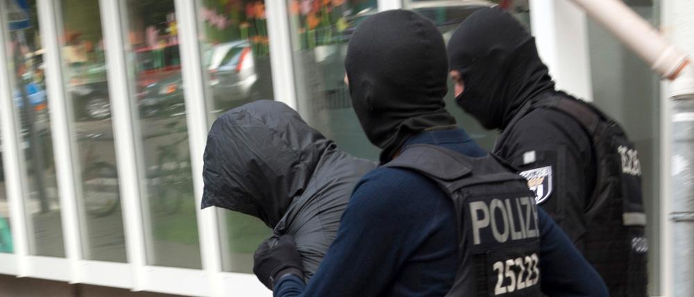 Polizeibeamte führen einen Mann ab.