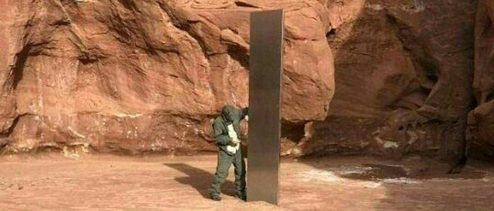 Ein Behördenmitarbeiter steht neben der Säule.