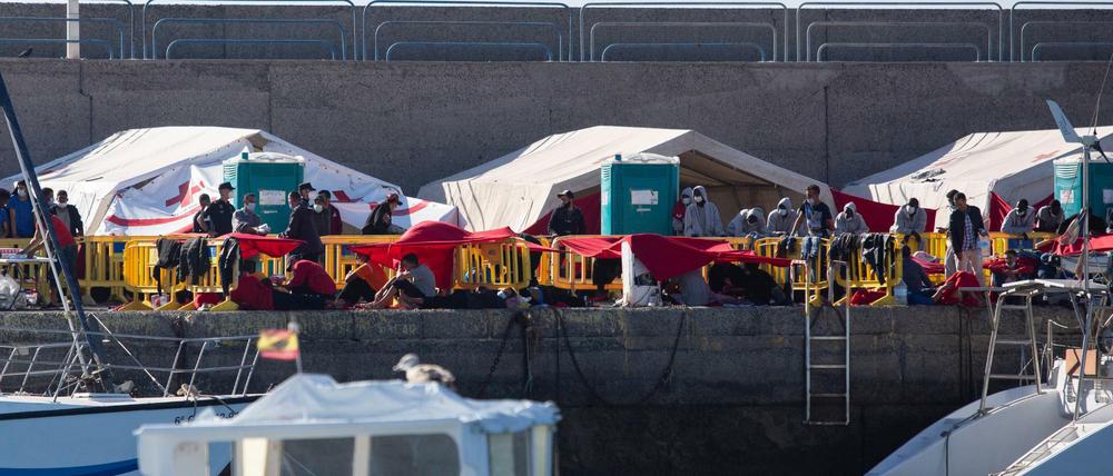 Migranten stehen an der Mole der Hafenstadt Arguineguín im Südwesten von Gran Canaria. Immer mehr Migranten wagen die Überfahrt aus Afrika auf die Kanaren.
