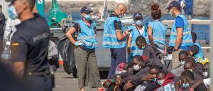 Migranten auf den Kanaren warten auf den Transfer zu ihren Unterkünften.