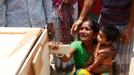 Schwester und die kleine Tochter einer getöteten Arbeiterin des Rana Plaza an ihrem Sarg. Die Fabrik in Bangladesh, die Billigmode für westliche Firmen herstellte, stürzte im April 2013 ein. Mehr als tausend Beschäftigte starben. Die Katastrophe löste Debatten über den Zusammenhang von Ausbeutung im Süden und Verschwendung im Norden der Welt aus.