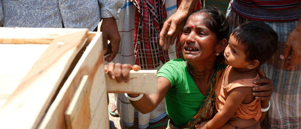 Schwester und die kleine Tochter einer getöteten Arbeiterin des Rana Plaza an ihrem Sarg. Die Fabrik in Bangladesh, die Billigmode für westliche Firmen herstellte, stürzte im April 2013 ein. Mehr als tausend Beschäftigte starben. Die Katastrophe löste Debatten über den Zusammenhang von Ausbeutung im Süden und Verschwendung im Norden der Welt aus.