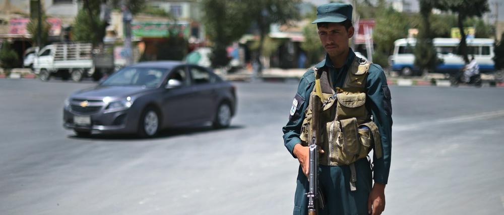 Ein afghanischer Polizist bewacht eine Straße nahe dem Flughafen in Kabul.