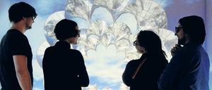 Vier wissenschaftliche Mitarbeiter:innen stehen vor einem 3-D-Modell einer Materialstruktur.