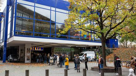 Studierende stehen vor einem modernen Mensagebäude Schlange.