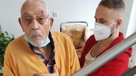 Krankengymnastik in Zeiten von Corona. Der schwer behinderte Orazio Giamblanco übt im Treppenhaus bei seiner Wohnung, trotz spastischer Lähmung am Geländer zu stehen. Physiotherapeut Tim Lange hilft.