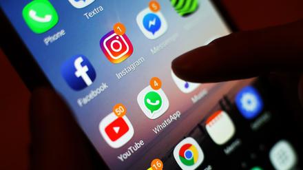 Ein Blick auf ein Smartphone mit den verschiedenen Social Media Apps, wie Facebook, Instagram, YouTube und WhatsApp. 