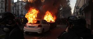Zwei Autos brennen in Paris während der Demonstration gegen das umstrittene Sicherheitsgesetz.