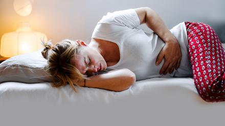 Eine Frau, die sich vor Menstruationsschmerzen krümmt - eben kein normales Bild. Denn oft steckt Endometriose dahinter.