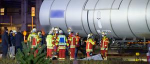 Rettungskräfte und Ermittler stehen neben den abgedeckten Leichen.